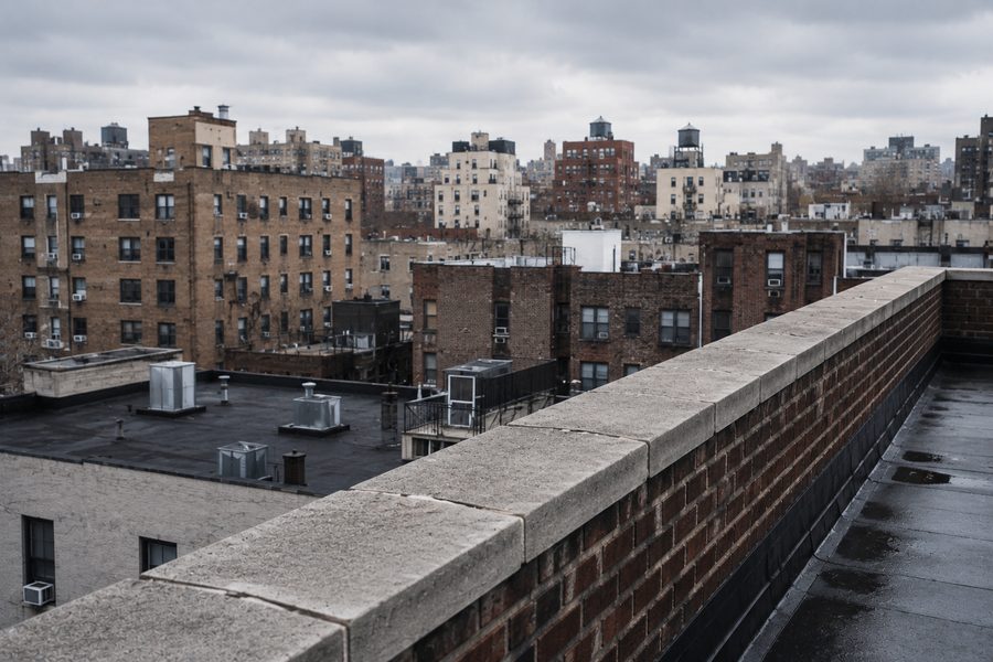 Street-facing masonry parapet run along a NYC rooftop